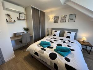 um quarto com uma cama grande e almofadas azuis em Nid douillet T2 rénové climatisé centre em Brive-la-Gaillarde