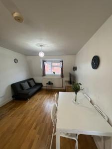 a living room with a white table and a couch at New build 2 bed flat, London in London