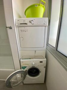 a washing machine with a bucket on top of it at Herzliya Luxury On The Park in Herzliya