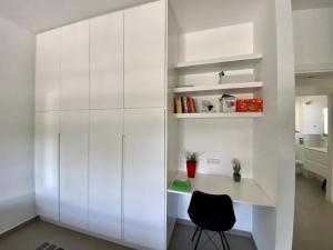 a white kitchen with a desk and a chair at Herzliya Luxury On The Park in Herzliya