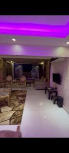 uma sala de estar com luzes roxas no tecto em شارع مراد على النيل no Cairo