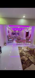 um quarto com cadeiras e luzes roxas num quarto em شارع مراد على النيل no Cairo