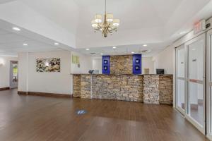 a large lobby with a stone wall and a chandelier at Comfort Inn US Hwy 80 in Demopolis