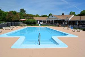 a swimming pool in a yard with tables and chairs at Quality Inn Raynham - Taunton in Raynham