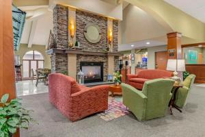 eine Lobby mit 2 Stühlen und einem Kamin in der Unterkunft Unity Hotel and Conference Ctr, Ascend Hotel Collection in Kansas City