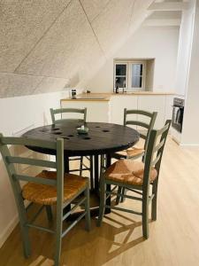 una mesa negra y sillas en una cocina en Lejlighed i naturskønt område, en Silkeborg