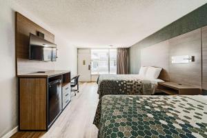 a hotel room with two beds and a television at Econo Lodge Inn & Suites Near Bricktown in Oklahoma City