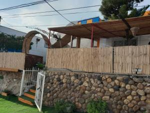 a house with a fence and a stone wall at גבעת האלון in Ein Kinya