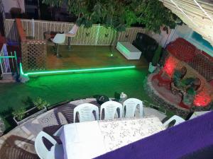 een achtertuin met een zwembad met een tafel en stoelen bij גבעת האלון in Ein Kinya