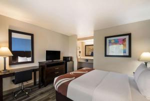 a hotel room with a bed and a flat screen tv at Quality Inn & Suites Round Rock in Round Rock