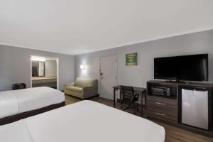 Habitación de hotel con 2 camas y TV de pantalla plana. en Econo Lodge near The Domain - The Arboretum en Austin