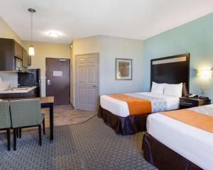 a hotel room with two beds and a kitchen at Suburban Studios Port Arthur in Port Arthur