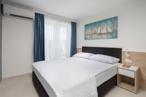 ein Schlafzimmer mit einem großen weißen Bett und einem Fenster in der Unterkunft Garden Palace Resort in Umag