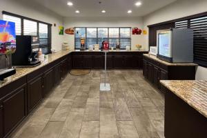 a large kitchen with dark wood cabinets and a large island at Quality Inn & Suites I-10 near Fiesta Texas in San Antonio