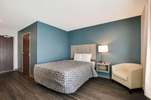 a bedroom with a bed and a chair in a room at WoodSpring Suites Knoxville - Cedar Bluff in Knoxville