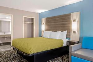 Quality Inn في نيوبيري: غرفه فندقيه بسرير وكرسي