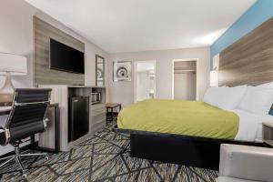 Quality Inn في نيوبيري: غرفة في الفندق مع سرير ومكتب