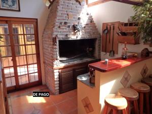 una cucina con camino in mattoni, bancone e sgabelli di Montelife a Montevideo