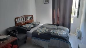 1 dormitorio pequeño con 1 cama y 1 silla en STUDIO TRES PROPRE de 18 m2 en Cergy