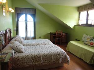 Dormitorio verde con 2 camas y ventana en Vivienda Sampedri, en Santillana del Mar
