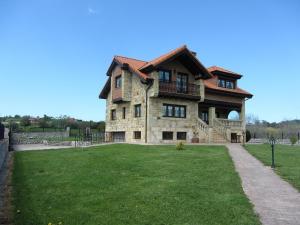una gran casa de piedra con un patio de césped en Vivienda Sampedri, en Santillana del Mar