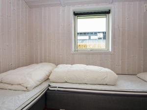 two beds in a room with a window at Three-Bedroom Holiday home in Juelsminde 18 in Sønderby
