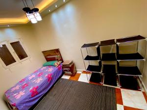 um quarto com uma cama e uma prateleira em The Home em Fayoum