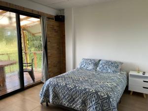 Schlafzimmer mit einem Bett und einer Glasschiebetür in der Unterkunft Meraki in Pereira