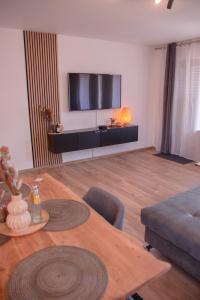 a living room with a table and a television at Viktoria‘s Ferienwohnung in Bad Harzburg