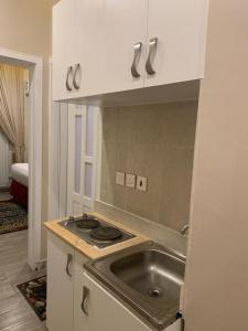 - une cuisine avec un évier et un comptoir dans l'établissement فندق ساسو سويت للوحدات المفروشه والفندقيه, à Farasan