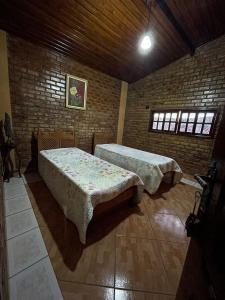 a room with two beds and a brick wall at Casa Sol nascente in Triunfo