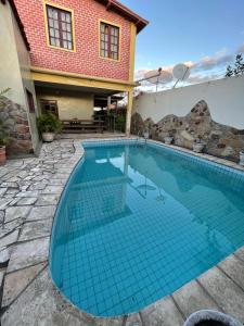 a swimming pool with blue tiles in a backyard at Casa amanhecer in Triunfo