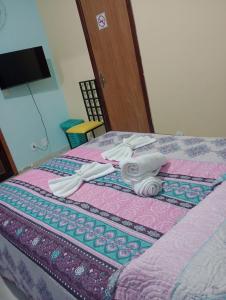 Una cama con dos utensilios encima. en CASA DA BARRA- Suítes privativas em Saquarema en Saquarema