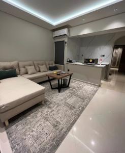 sala de estar con sofá y mesa en رواق الضيافة للشقق المخدومة RWAQ Hotel, en Jazan