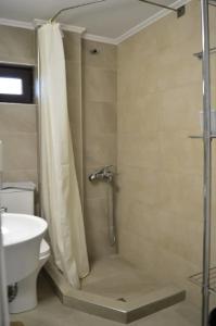 La salle de bains est pourvue d'une douche, de toilettes et d'un lavabo. dans l'établissement Calma Kourouta Apartments, à Kourouta