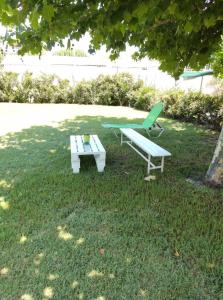 stół piknikowy i ławka w trawie w obiekcie Calma Kourouta Apartments w mieście Kourouta