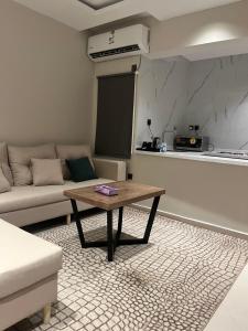 a living room with a table and a couch at رواق الضيافة للشقق المخدومة in Jazan