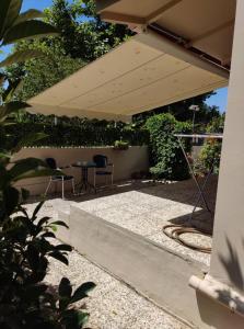 a patio with a table and chairs under an umbrella at Calma Kourouta Apartments in Kourouta +60 photos