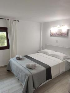 Un dormitorio blanco con una cama con toallas. en Calma Kourouta Apartments, en Kourouta