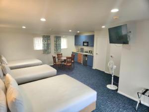 a hotel room with a bed and a kitchen with a table at Botany Palms Motel in Auckland