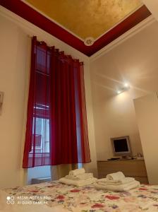 ナポリにあるNella Storica Piazza Carlo IIIのベッドルーム1室(赤いカーテン付きのベッド1台付)