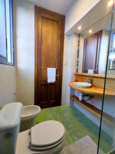 a bathroom with a toilet and a sink and a mirror at Espectacular Casa !Inmejorable ubicación in Salto