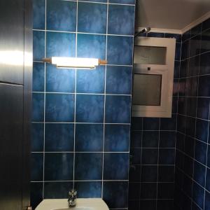 a bathroom with blue tiled walls and a toilet at Flat 11 B, Villa 29, Porto sharm El sheikh in Sharm El Sheikh
