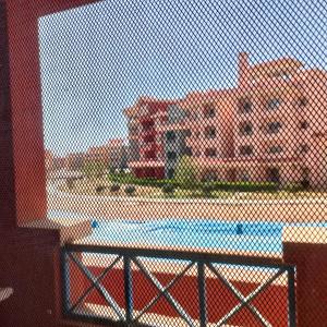 a chain link fence with a view of a building at Flat 11 B, Villa 29, Porto sharm El sheikh in Sharm El Sheikh