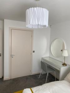 1 dormitorio con escritorio, espejo y cama en Marine Viewing 2 bedrooms flat en Mánchester