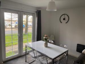 Una mesa blanca con un jarrón de flores. en Marine Viewing 2 bedrooms flat en Mánchester