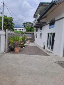 una casa blanca con plantas delante en Laure hebergement loue des lits en dortoir en Faaa