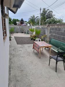 een patio met een tafel en een bank bij Laure hebergement loue des lits en dortoir in Faaa