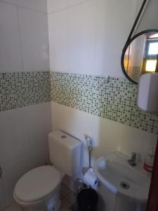 a small bathroom with a toilet and a sink at CASA DA BARRA- Suítes privativas em Saquarema in Saquarema