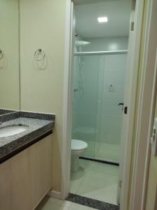 Un baño con ducha de cristal y un inodoro. en Apartamento em Ondina, en Salvador